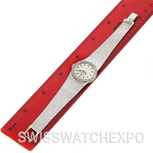 The image shows the entire Vintage Ladies 14k White Gold Diamond Watch model by Omega 7816 Women's White Gold Silver Dial 7816 Women's White Gold Silver Dial laid flat against a red ruler for scale.
