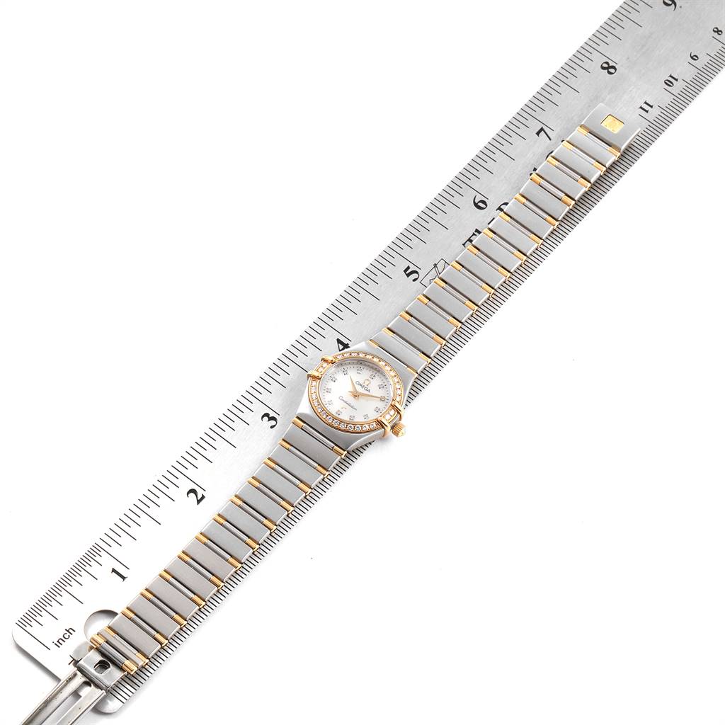 The Omega 1367.75.00 Women
s Steel and Gold (two tone) Mother of Pearl Dial 1367.75.00 Women
s Steel and Gold (two tone) Mother of Pearl Dial Constellation Steel Yellow Gold Diamond Ladies 1367.75.00 watch is displayed flat with a ruler, showcasing the face and strap.
