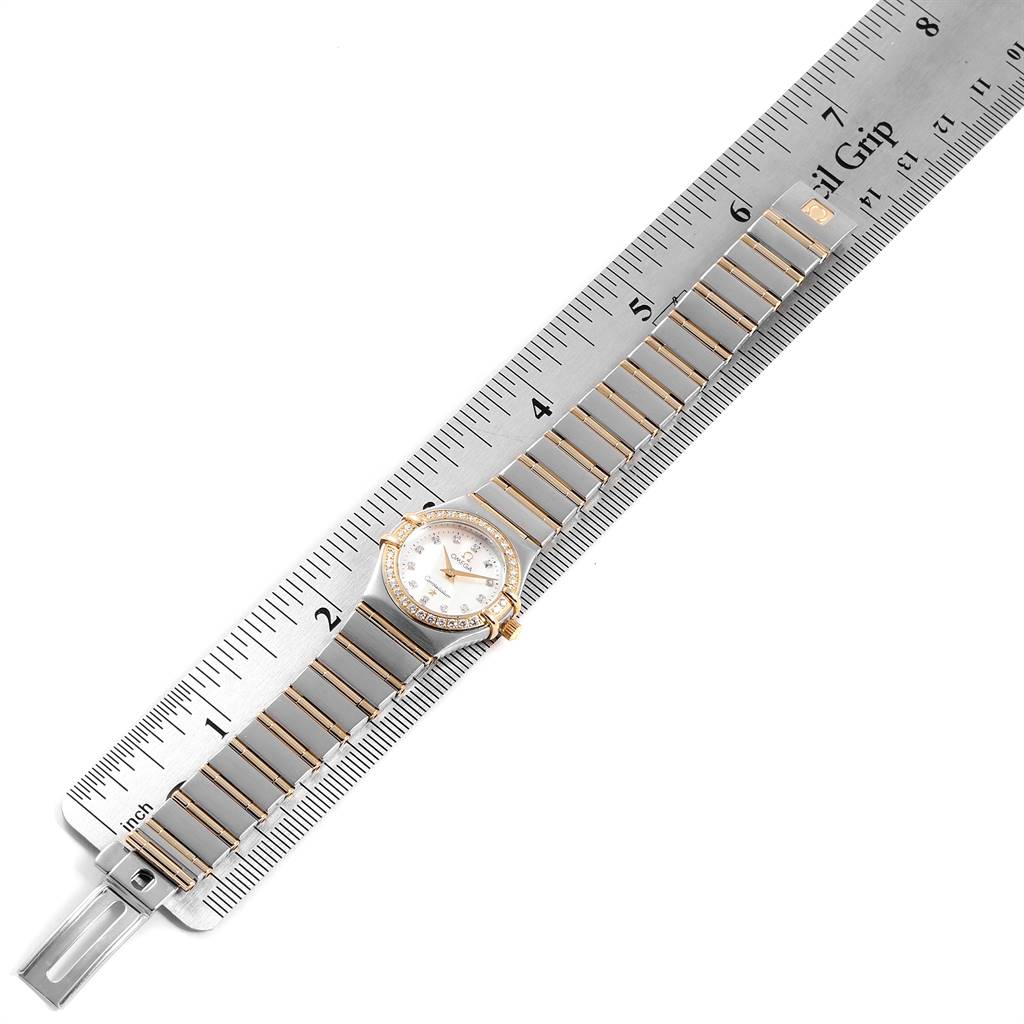 The Omega 1267.75.00 Women's Steel and Gold (two tone) Mother of Pearl Dial 1267.75.00 Women's Steel and Gold (two tone) Mother of Pearl Dial Constellation 95 Mother of Pearl Diamond Ladies Watch 1267.75.00 is shown flat, with the watch face, band, and ruler for scale.