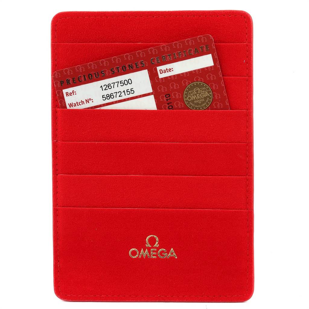 The image shows a red Omega 1267.75.00 Women's Steel and Gold (two tone) Mother of Pearl Dial 1267.75.00 Women's Steel and Gold (two tone) Mother of Pearl Dial cardholder holding the certification card for the Omega 1267.75.00 Women's Steel and Gold (two tone) Mother of Pearl Dial 1267.75.00 Women's Steel and Gold (two tone) Mother of Pearl Dial Constellation MOP Diamond Ladies Watch 1267.75.00.