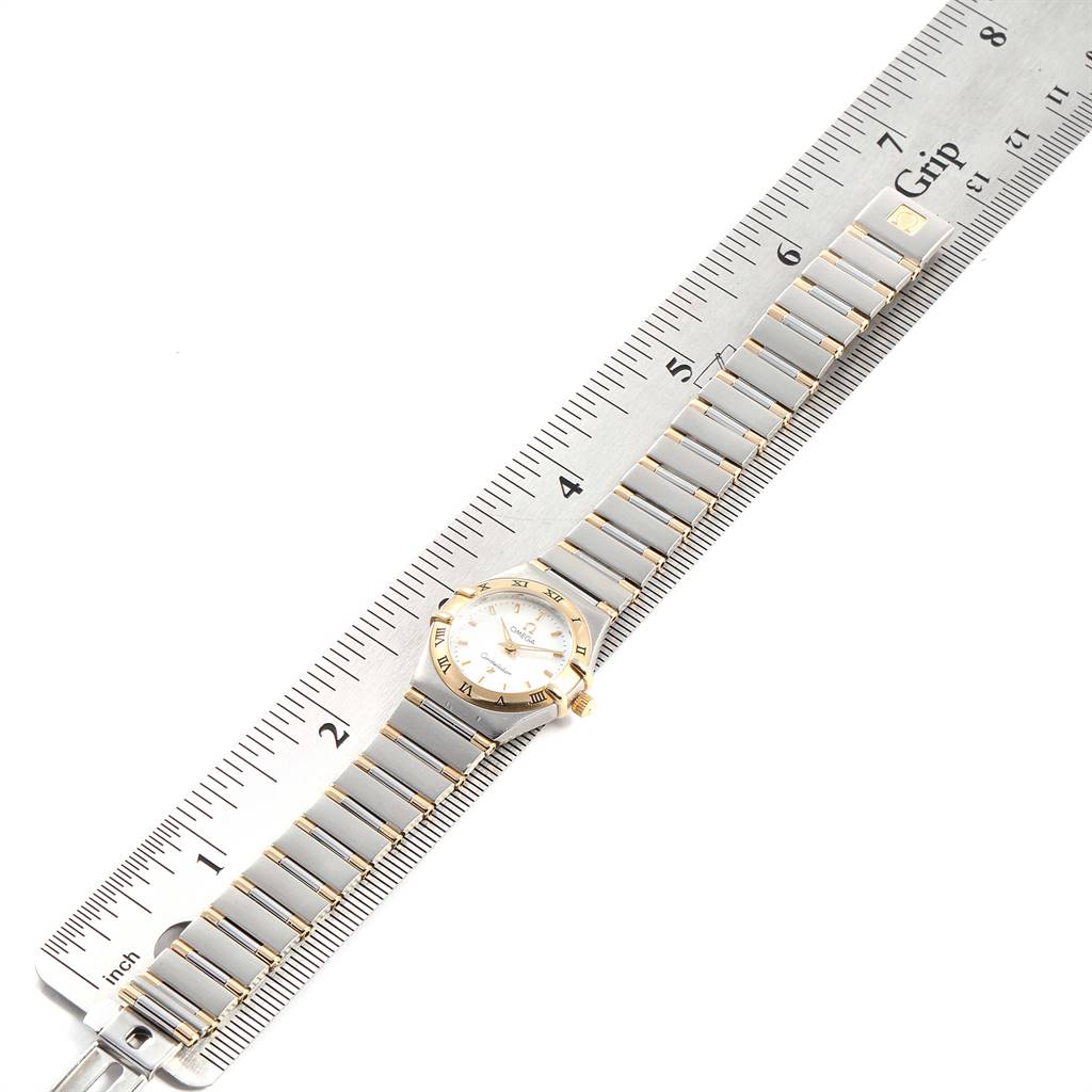 This image shows an Omega 1372.70.00 Women's Steel and Gold (two tone) Mother of Pearl Dial 1372.70.00 Women's Steel and Gold (two tone) Mother of Pearl Dial Constellation Steel Yellow Gold Mother of Pearl Ladies Watch lying flat next to a ruler for measurement.