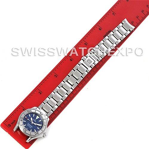 The image shows an Omega 2224.80.00 Women
s Stainless Steel Blue Dial 2224.80.00 Women
s Stainless Steel Blue Dial Seamaster Steel Ladies Watch 2285.80.00 laid flat against a red ruler, displaying the entire watch.