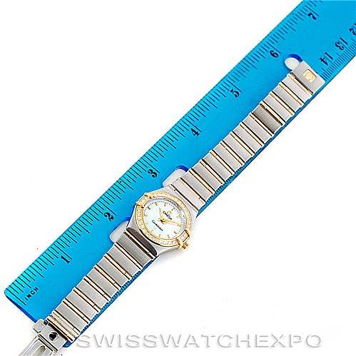 The image shows an overhead view of the Omega 1267.70.00 Women
s Steel and Gold (two tone) Mother of Pearl Dial 1267.70.00 Women
s Steel and Gold (two tone) Mother of Pearl Dial Constellation My Choice Steel Gold Diamond Watch 1267.70.00 with a blue ruler for scale.