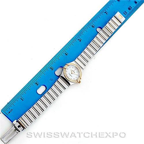 The image shows an overhead view of the Omega 1365.75.00 Women
s Steel and Gold (two tone) Mother of Pearl Dial 1365.75.00 Women
s Steel and Gold (two tone) Mother of Pearl Dial Ladies Constellation Diamond Mini 1365.75.00 watch with its band extended alongside a ruler.