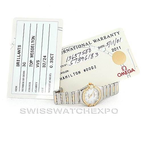 The image shows an Omega 1365.75.00 Women
s Steel and Gold (two tone) Mother of Pearl Dial 1365.75.00 Women
s Steel and Gold (two tone) Mother of Pearl Dial Ladies Constellation Diamond Mini 1365.75.00 watch with warranty and certification cards, viewed from above.