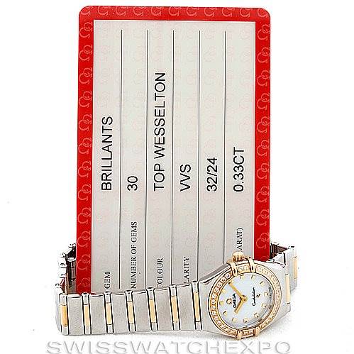 The image shows the Omega 1365.71.00 Women
s Steel and Gold (two tone) Mother of Pearl Dial 1365.71.00 Women
s Steel and Gold (two tone) Mother of Pearl Dial Ladies Constellation Diamond Mini 1365.71.00 watch at a frontal angle with its bracelet and certificate.