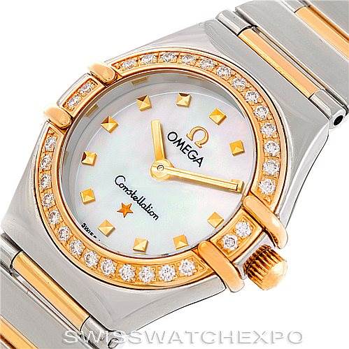 The image shows a close-up, angled view of the Ladies Omega 1365.71.00 Women
s Steel and Gold (two tone) Mother of Pearl Dial 1365.71.00 Women
s Steel and Gold (two tone) Mother of Pearl Dial Constellation Diamond Mini 1365.71.00 watch face and part of the bracelet.