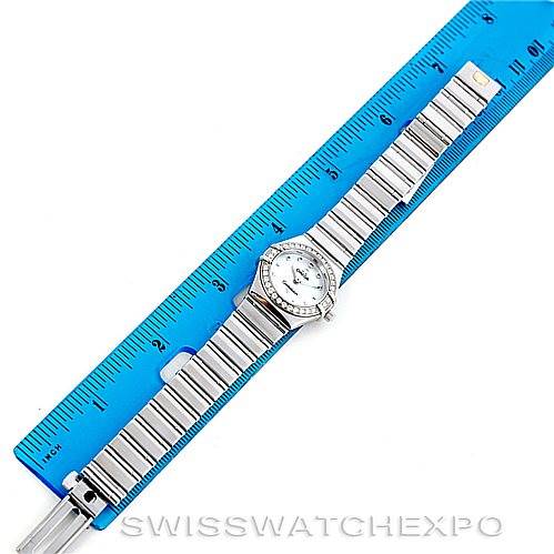 The image shows a top-down view of the Omega 1465.71.00 Women
s Stainless Steel Mother of Pearl Dial 1465.71.00 Women
s Stainless Steel Mother of Pearl Dial Constellation My Choice Ladies Mini Watch 1465.71.00 with a blue ruler measuring the bracelet length.