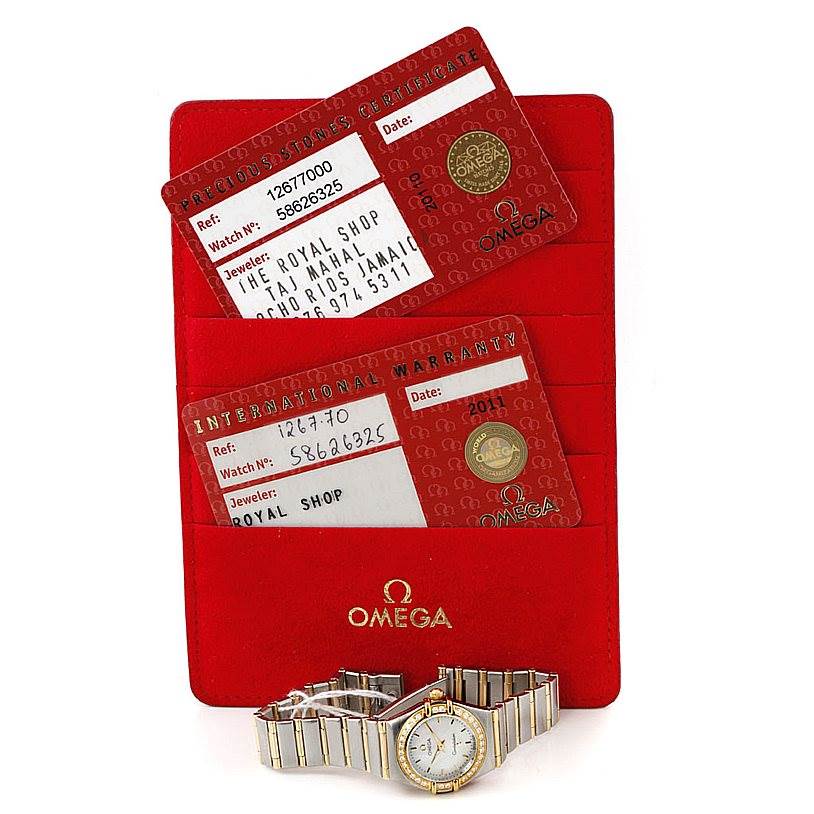 The image shows an Omega 1267.70.00 Women
s Steel and Gold (two tone) Mother of Pearl Dial 1267.70.00 Women
s Steel and Gold (two tone) Mother of Pearl Dial Constellation Ladies Diamond Mini Watch 1267.70.00, warranty cards, and a red holder.