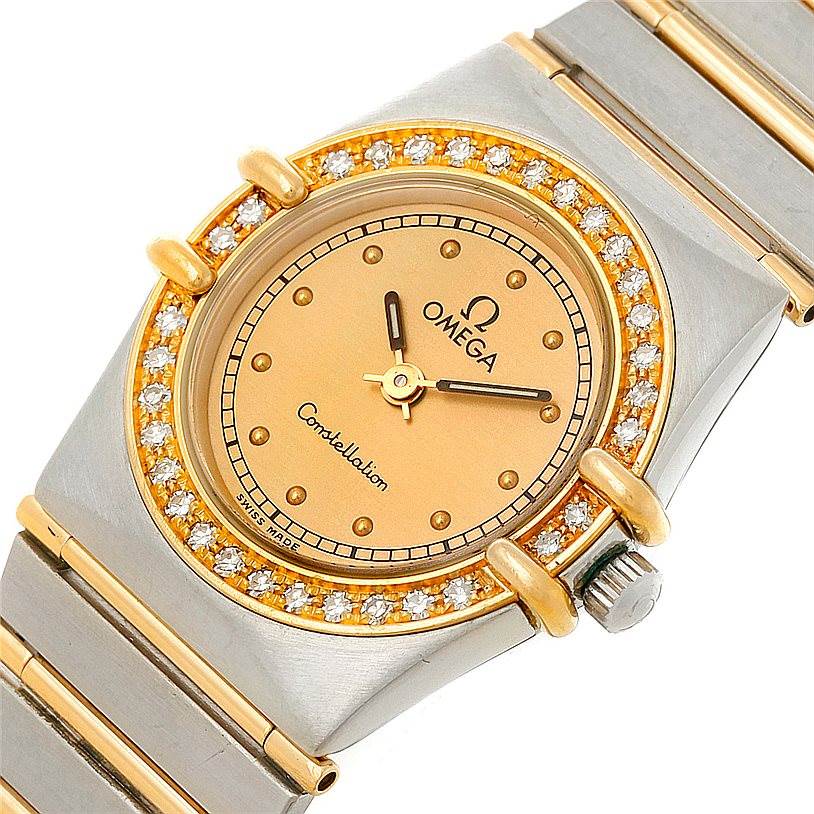 The image shows a close-up of the Omega Women
s Steel and Gold (two tone) Champagne Dial Women
s Steel and Gold (two tone) Champagne Dial Constellation Mini Steel 18K Yellow Gold Diamond Watch, highlighting the dial, bezel, and part of the bracelet.