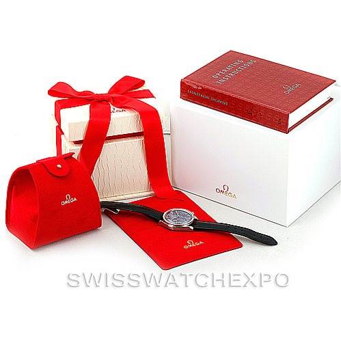 The image shows the Omega 3835.76.31 Women
s Stainless Steel Mother of Pearl Dial 3835.76.31 Women
s Stainless Steel Mother of Pearl Dial Speedmaster Ladies Diamond MOP Dial Watch 3835.76.31 with its box, red case, and accessories from a side angle.