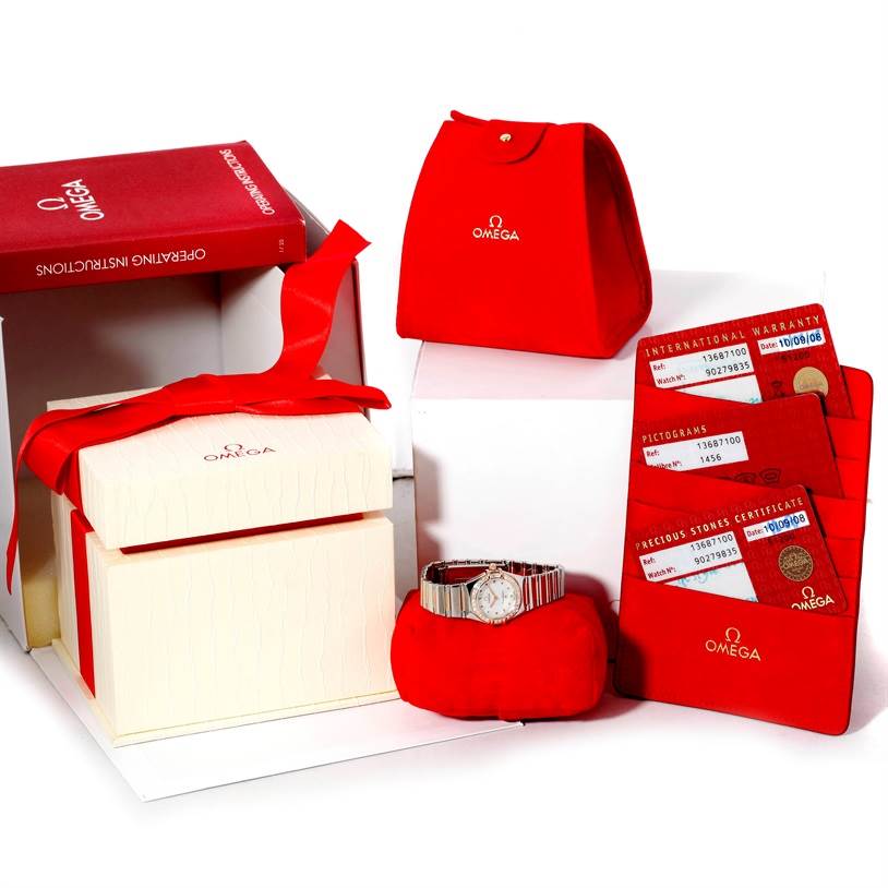 The image shows the Omega 1368.71.00 Women
s Steel and Gold (two tone) Mother of Pearl Dial 1368.71.00 Women
s Steel and Gold (two tone) Mother of Pearl Dial Constellation My Choice Mini Diamond Watch 1368.71.00 with its box, red pouch, cards, and instruction manual.