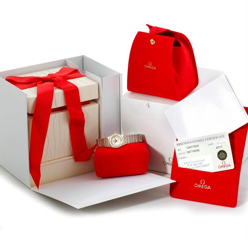 The image shows the Omega 1267.75.00 Women
s Steel and Gold (two tone) Mother of Pearl Dial 1267.75.00 Women
s Steel and Gold (two tone) Mother of Pearl Dial Constellation My Choice Steel Gold Diamond Watch 1267.75.00 with its box, certificate, and red pouches.