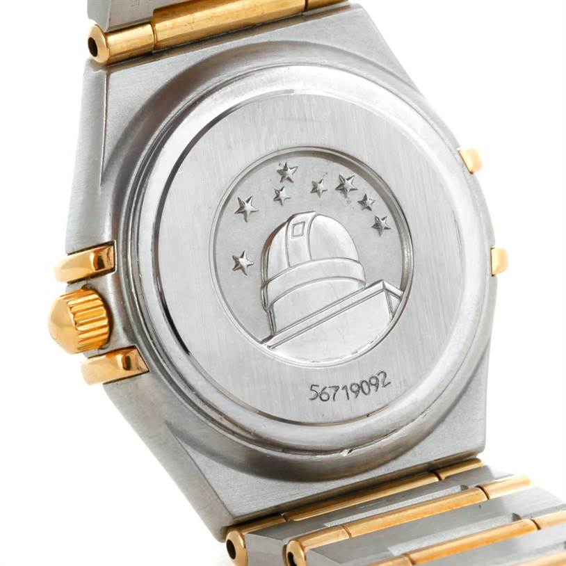 The image shows the back casing and part of the bracelet of an Omega 1267.75.00 Women
s Steel and Gold (two tone) Mother of Pearl Dial 1267.75.00 Women
s Steel and Gold (two tone) Mother of Pearl Dial Constellation My Choice Steel Gold Diamond Watch 1267.75.00.