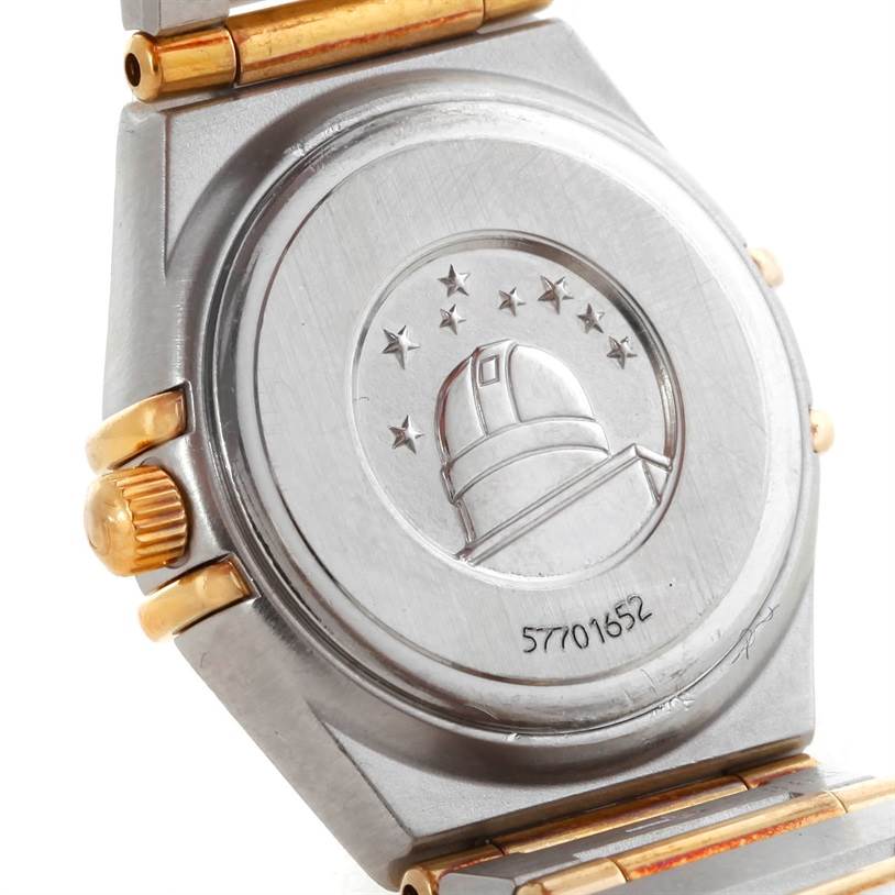 The image shows the case back of the Omega 1267.75.00 Women
s Steel and Gold (two tone) Mother of Pearl Dial 1267.75.00 Women
s Steel and Gold (two tone) Mother of Pearl Dial Constellation My Choice Steel Gold Diamond Watch 1267.75.00 with gold accents and an engraved design.
