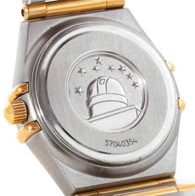The image shows the back case of the Omega 1267.70.00 Women
s Steel and Gold (two tone) Mother of Pearl Dial 1267.70.00 Women
s Steel and Gold (two tone) Mother of Pearl Dial Constellation My Choice Mini Steel Gold Diamond Watch 1267.70.00 at an angled view.