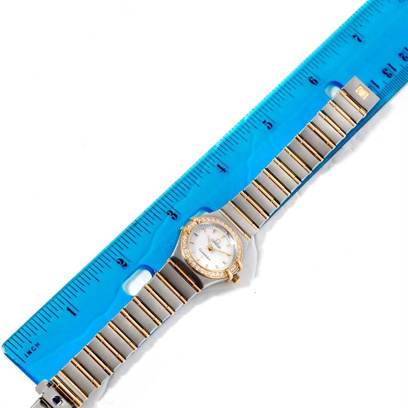 The Omega 1267.70.00 Women
s Steel and Gold (two tone) Mother of Pearl Dial 1267.70.00 Women
s Steel and Gold (two tone) Mother of Pearl Dial Constellation My Choice Mini Steel Gold Diamond Watch 1267.70.00 is shown laying flat with a ruler for scale.