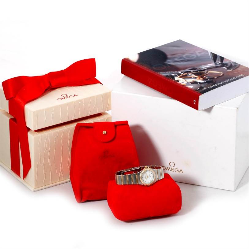 The image shows an Omega 1267.70.00 Women
s Steel and Gold (two tone) Mother of Pearl Dial 1267.70.00 Women
s Steel and Gold (two tone) Mother of Pearl Dial Constellation My Choice Mini Steel Gold Diamond Watch 1267.70.00 with its packaging, pouches, and booklet.