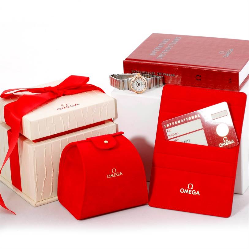 The image shows the Omega 1360.75.00 Women
s Steel and Gold (two tone) Mother of Pearl Dial 1360.75.00 Women
s Steel and Gold (two tone) Mother of Pearl Dial Constellation My Choice Mini Diamond Watch 1360.75.00 model along with its box, pouch, and warranty card.