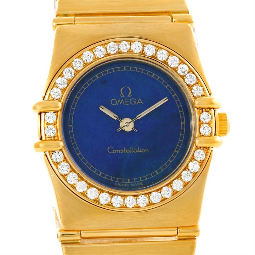The image shows a frontal view of the Omega Women
s Blue Dial Women
s Blue Dial Constellation 18K Yellow Gold Diamond Lapis Dial Watch, focusing on its face and top bracelet part.