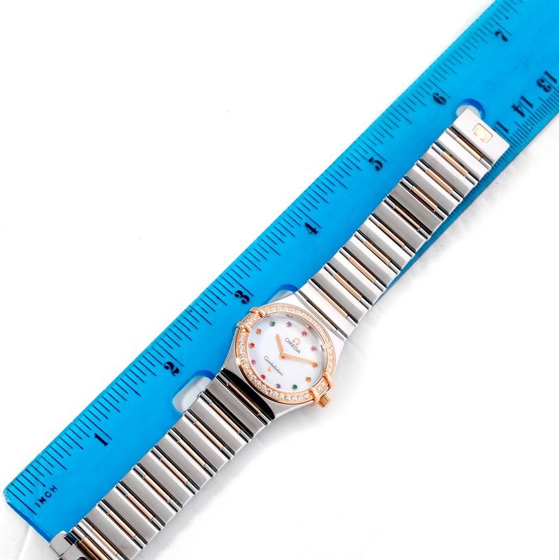 The Omega 1358.79.00 Women
s Steel and Gold (two tone) Mother of Pearl Dial 1358.79.00 Women
s Steel and Gold (two tone) Mother of Pearl Dial Constellation Iris 1358.79.00 watch is shown from above, with the face, bracelet, and part of a blue ruler visible.