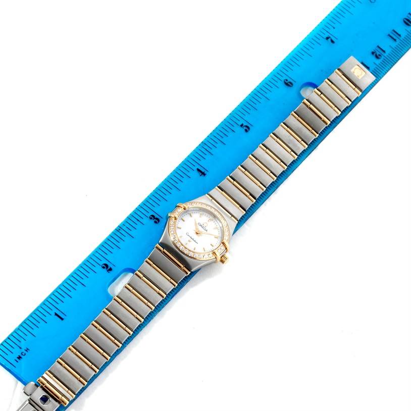The Omega 1267.70.00 Women
s Steel and Gold (two tone) Mother of Pearl Dial 1267.70.00 Women
s Steel and Gold (two tone) Mother of Pearl Dial Constellation My Choice Mini Steel Gold Diamond Watch 1267.70.00 is shown from a top-down angle with a ruler for scale.