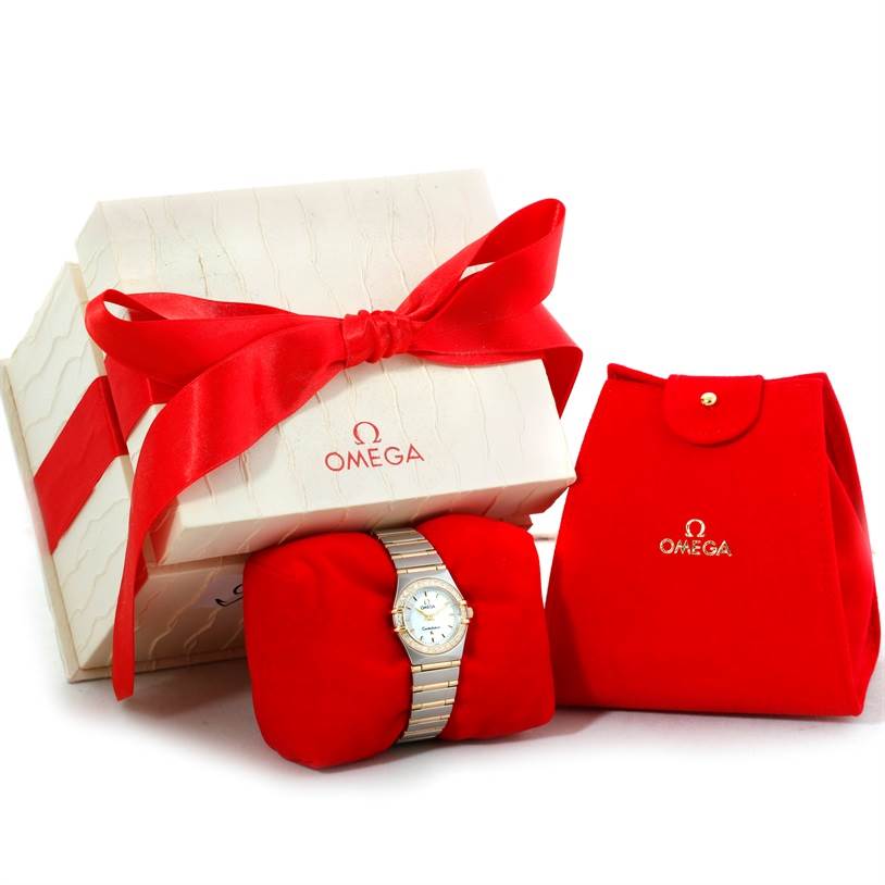 The image shows an Omega 1267.70.00 Women
s Steel and Gold (two tone) Mother of Pearl Dial 1267.70.00 Women
s Steel and Gold (two tone) Mother of Pearl Dial Constellation My Choice Mini Steel Gold Diamond Watch 1267.70.00 alongside its branded packaging.