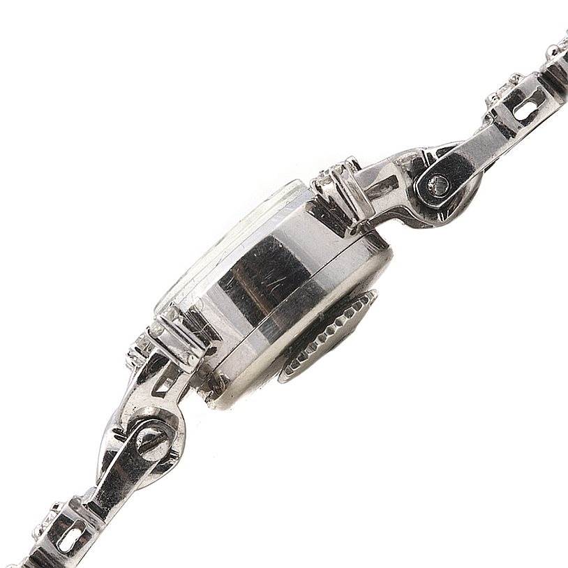 The image shows a side view of the Longines Women's White Gold Silver Dial Women's White Gold Silver Dial Vintage Ladies 14k w Gold Diamonds Watch, focusing on the case, crown, and part of the bracelet.