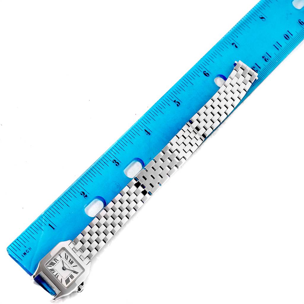 The image shows a Cartier Santos Demoiselle W25065Z5 Women's Steel and Gold (two tone) Silver Dial W25065Z5 Women's Steel and Gold (two tone) Silver Dial watch laying flat against a blue ruler, highlighting the face and bracelet band.