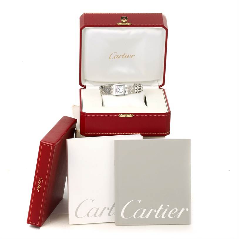 The Cartier Santos Demoiselle W25075Z5 Women's Stainless Steel Mother of Pearl Dial W25075Z5 Women's Stainless Steel Mother of Pearl Dial watch is displayed inside an open box with additional packaging and booklets surrounding it.
