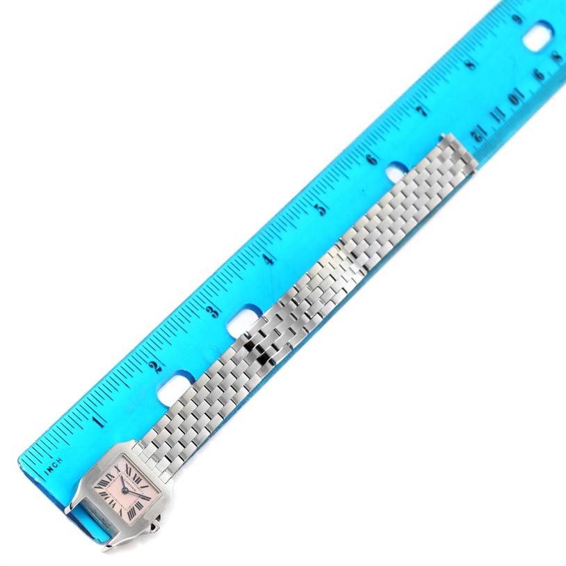 The image shows a Cartier Santos Demoiselle W25075Z5 Women
s Stainless Steel Mother of Pearl Dial W25075Z5 Women
s Stainless Steel Mother of Pearl Dial watch laid flat with a blue ruler for measurement.