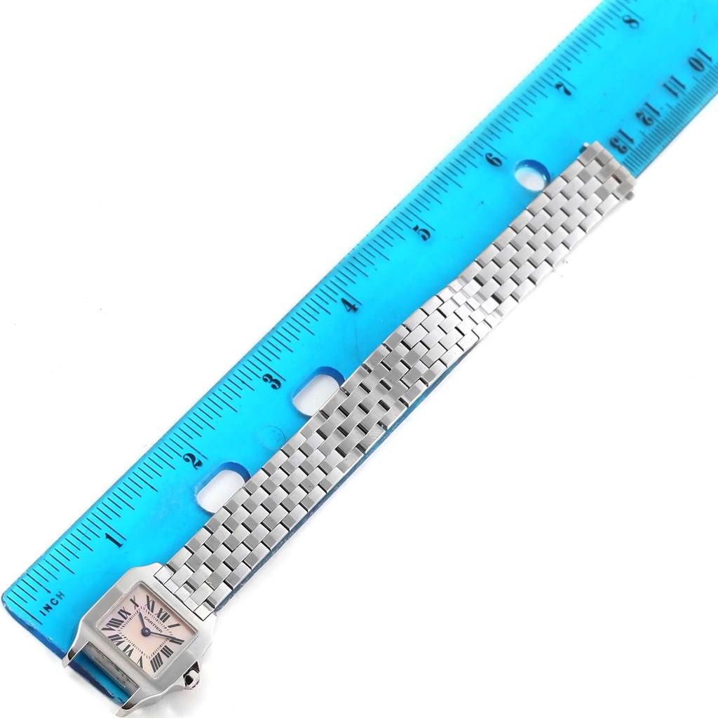 The image shows a top-down view of a Cartier Santos Demoiselle W25075Z5 Women's Stainless Steel Mother of Pearl Dial W25075Z5 Women's Stainless Steel Mother of Pearl Dial watch, with emphasis on its face, bezel, and bracelet laid beside a ruler.