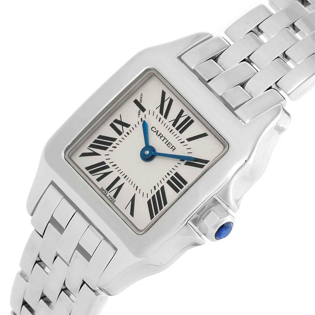 The image shows a close-up of the Cartier Santos Demoiselle W25064Z5 Men's Stainless Steel Silver Dial W25064Z5 Men's Stainless Steel Silver Dial watch, highlighting its face, blue hands, bezel, and part of the bracelet.