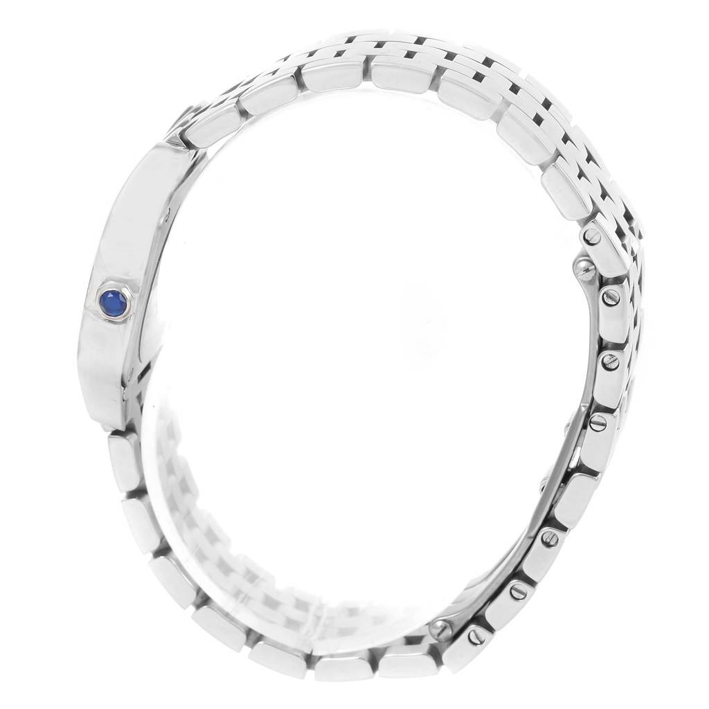 The image shows the side view of a Santos Demoiselle watch by Cartier, highlighting its metal bracelet and crown with a blue gemstone.