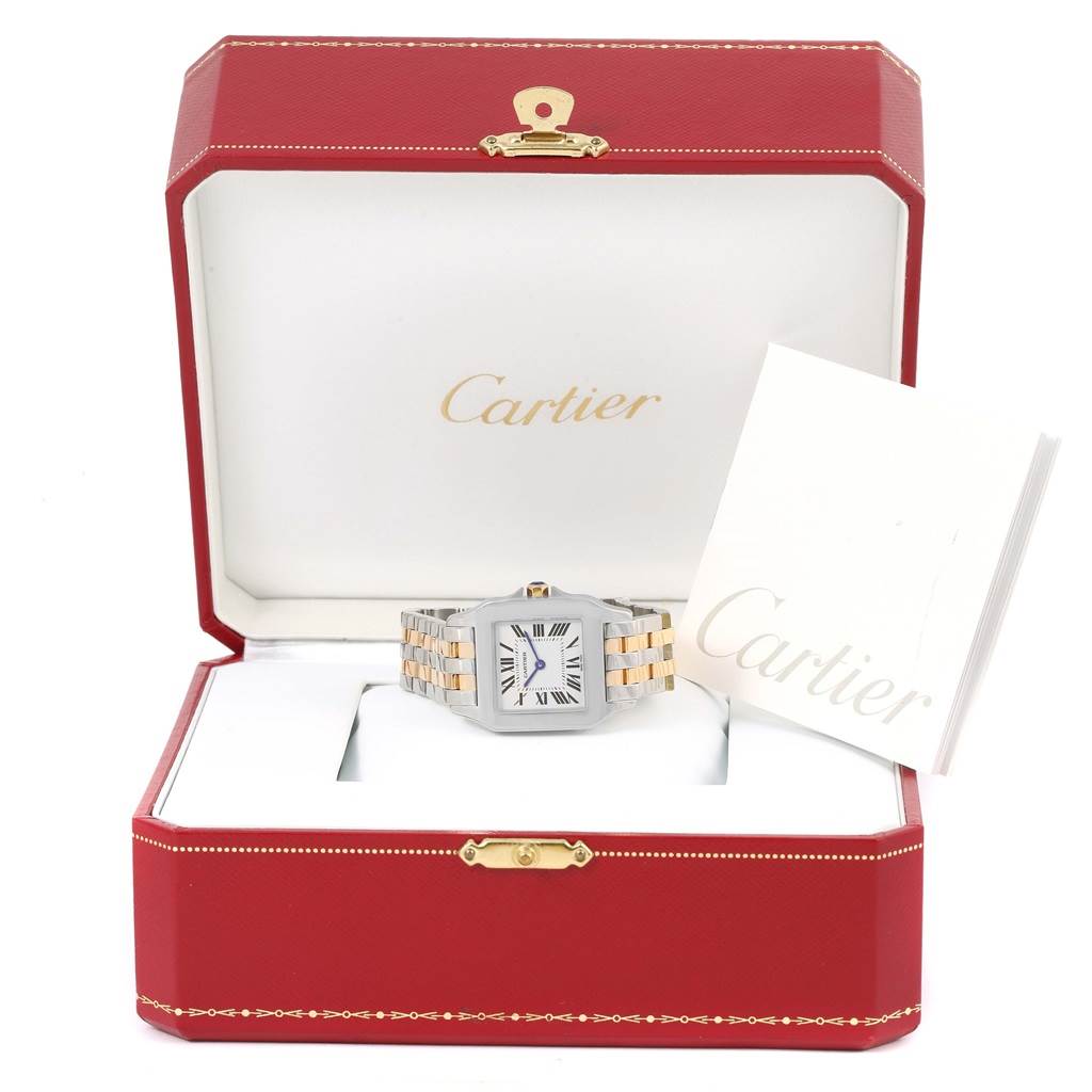 The Cartier Santos Demoiselle W25067Z6 Women's Steel and Gold (two tone) Silver Dial W25067Z6 Women's Steel and Gold (two tone) Silver Dial watch is displayed front-on inside its branded red box with a booklet.