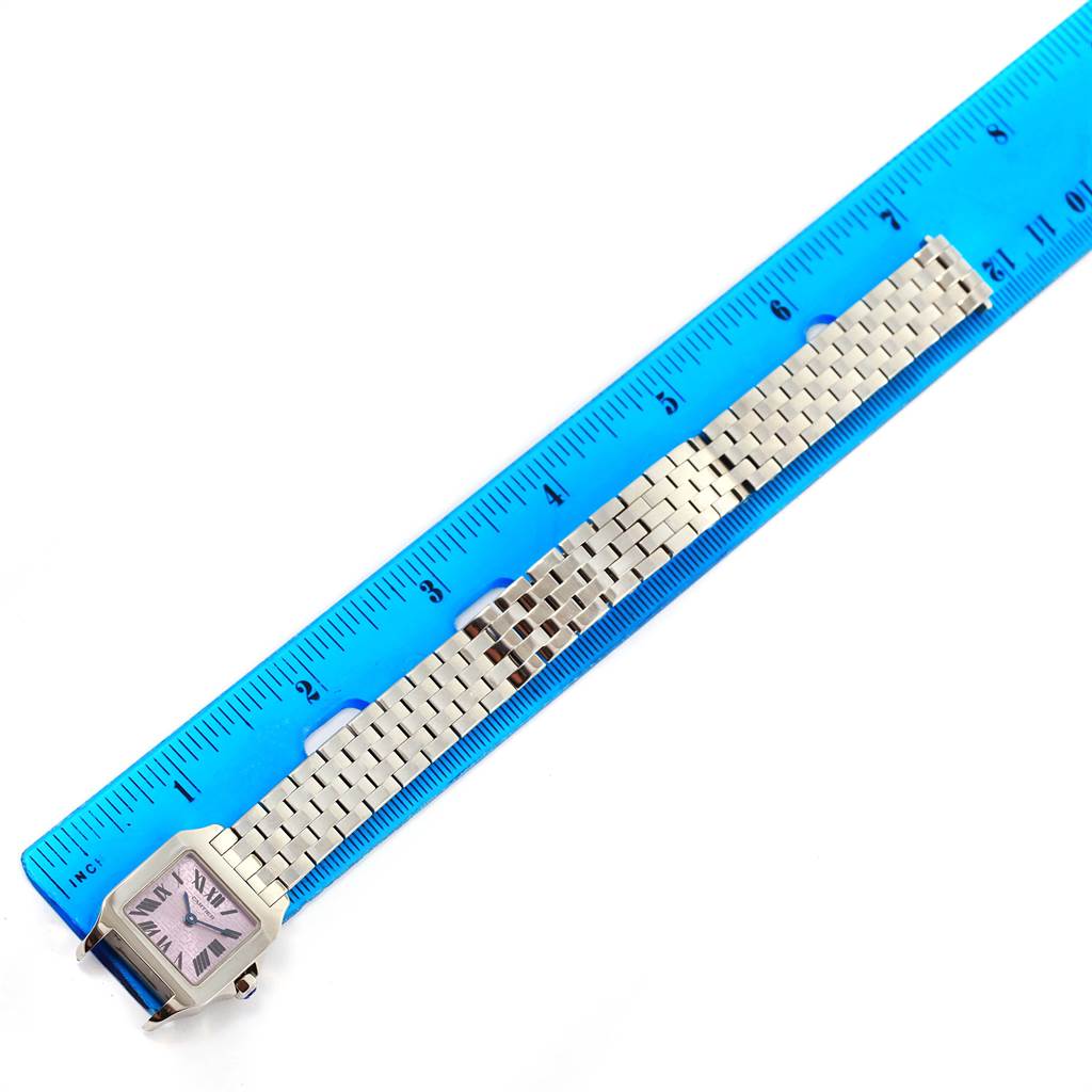 The Cartier Santos Demoiselle W2510002 Women's Stainless Steel Purple Dial W2510002 Women's Stainless Steel Purple Dial watch is shown from a top-down angle next to a blue ruler, displaying its face and metal bracelet.