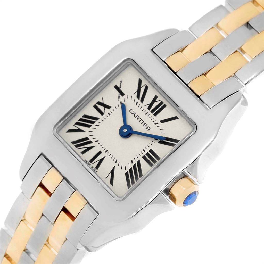 This image shows the Cartier Santos Demoiselle W25066Z6 Women's Steel and Gold (two tone) Silver Dial W25066Z6 Women's Steel and Gold (two tone) Silver Dial watch at an angle highlighting its square face, roman numeral dial, blue hands, crown, and two-tone bracelet.