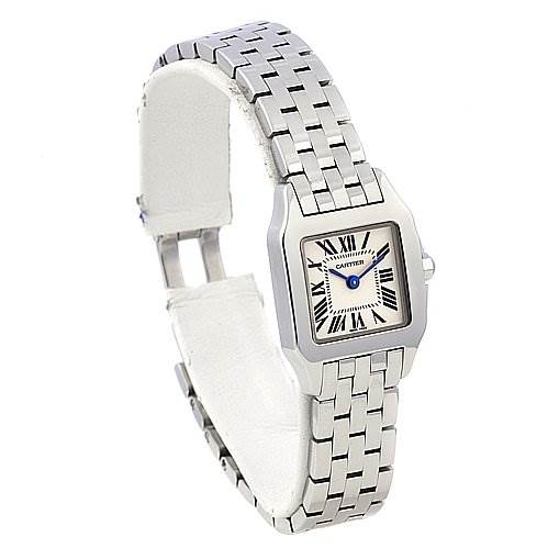 This image shows a Cartier Santos Demoiselle W25064Z5 Women's Stainless Steel White Dial W25064Z5 Women's Stainless Steel White Dial watch, emphasizing its square face, Roman numerals, and metallic bracelet from an angled view.