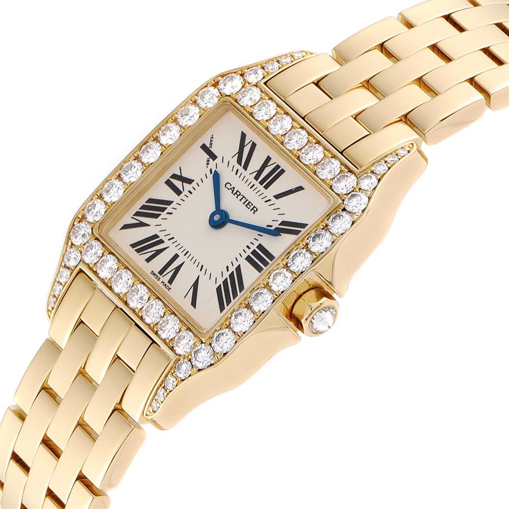 The image shows a close-up angle of the Cartier Santos Demoiselle WF9002Y7 Women
s Yellow Gold Silver Dial WF9002Y7 Women
s Yellow Gold Silver Dial watch, highlighting its face, diamond bezel, and part of the bracelet.
