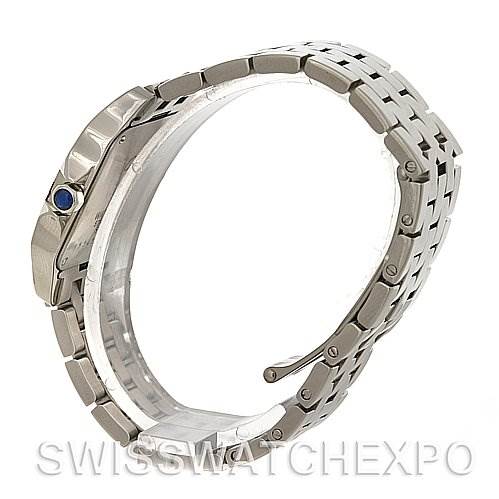 The image shows a side view of the Cartier Santos Demoiselle W25065Z5 Women's Steel and Gold (two tone) Silver Dial W25065Z5 Women's Steel and Gold (two tone) Silver Dial watch, focusing on its metallic bracelet and the crown set with a blue gem.