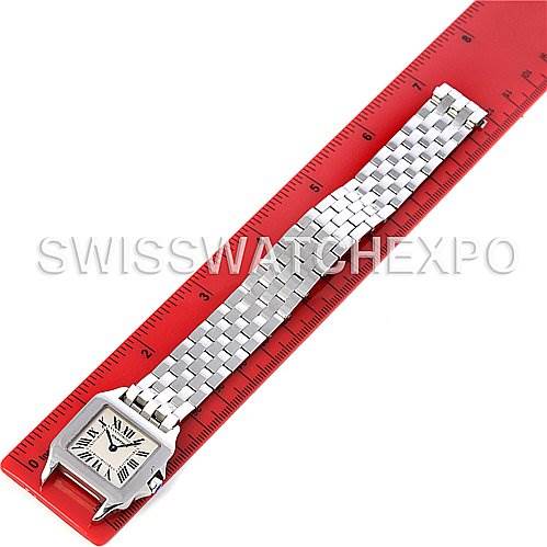 The image shows a Cartier Santos Demoiselle W25065Z5 Women's Steel and Gold (two tone) Silver Dial W25065Z5 Women's Steel and Gold (two tone) Silver Dial watch laid flat on a red ruler, showcasing the face and bracelet.