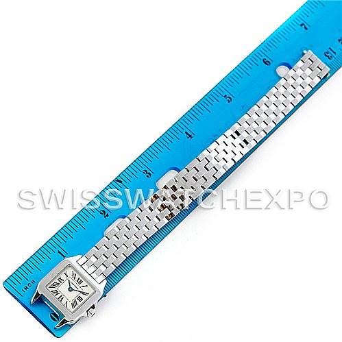 The image shows a Cartier Santos Demoiselle W25064Z5 Women
s Stainless Steel Silver Dial W25064Z5 Women
s Stainless Steel Silver Dial watch laid flat next to a ruler, displaying the face, bracelet, and clasp.