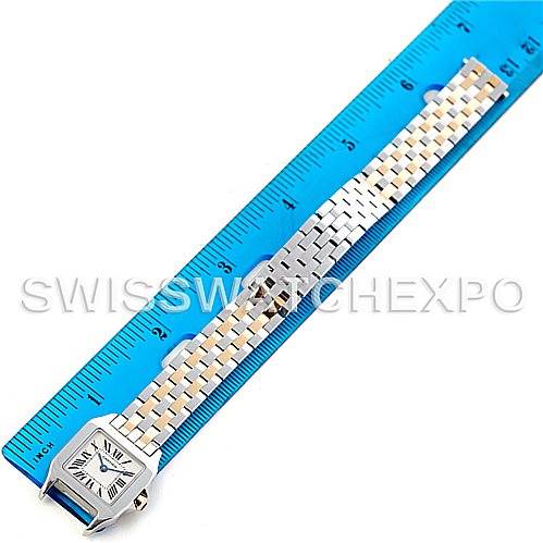 The image shows a top-down view of a Cartier Santos Demoiselle W25066Z6 Women's Steel and Gold (two tone) Silver Dial W25066Z6 Women's Steel and Gold (two tone) Silver Dial watch, displaying its face and metal bracelet alongside a ruler for scale.