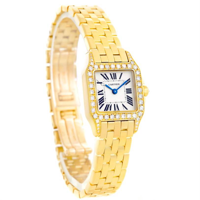 The Cartier Santos Demoiselle WF9001Y7 Women's Yellow Gold Silver Dial WF9001Y7 Women's Yellow Gold Silver Dial watch is shown at an angle from the front and left side, displaying the face, bezel, and bracelet.