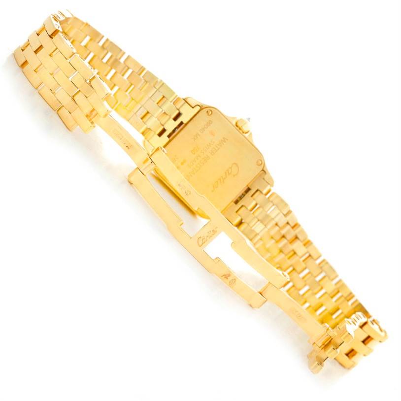 The image shows the backside of a Cartier Santos Demoiselle WF9001Y7 Women's Yellow Gold Silver Dial WF9001Y7 Women's Yellow Gold Silver Dial watch with an open bracelet and visible clasp mechanism.