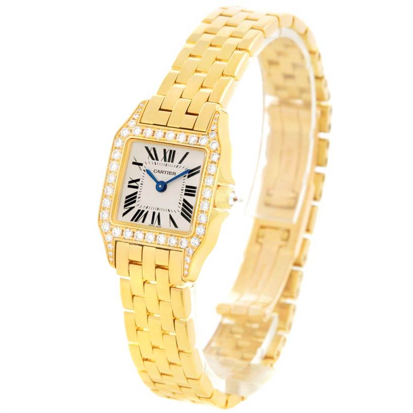 The image shows a Cartier Santos Demoiselle WF9001Y7 Women's Yellow Gold Silver Dial WF9001Y7 Women's Yellow Gold Silver Dial watch at a three-quarter angle, highlighting its gold bracelet and diamond-studded bezel.