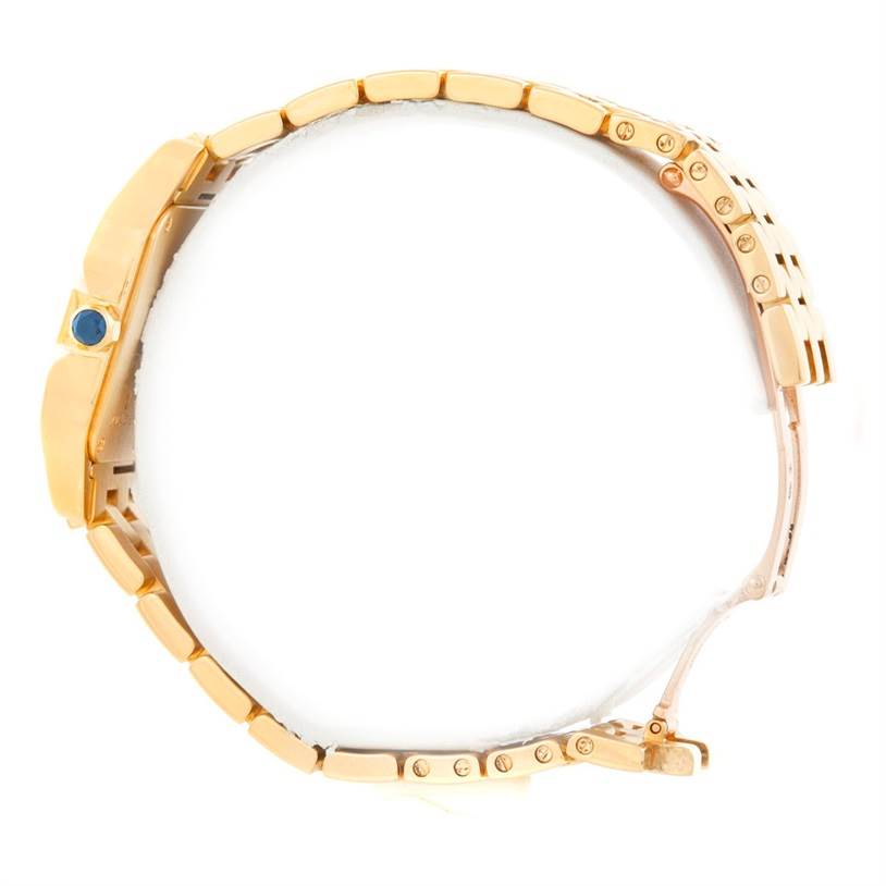 The image shows a side view of the Cartier Santos Demoiselle W25062X9 Women's Yellow Gold Silver Dial W25062X9 Women's Yellow Gold Silver Dial model watch, highlighting its gold bracelet and blue cabochon crown.