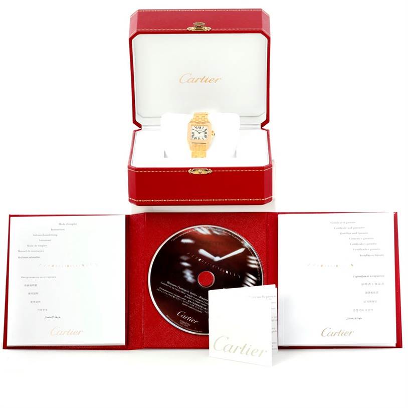 The image shows the Cartier Santos Demoiselle W25062X9 Women's Yellow Gold Silver Dial W25062X9 Women's Yellow Gold Silver Dial watch in its red box, along with its accompanying documents and CD.