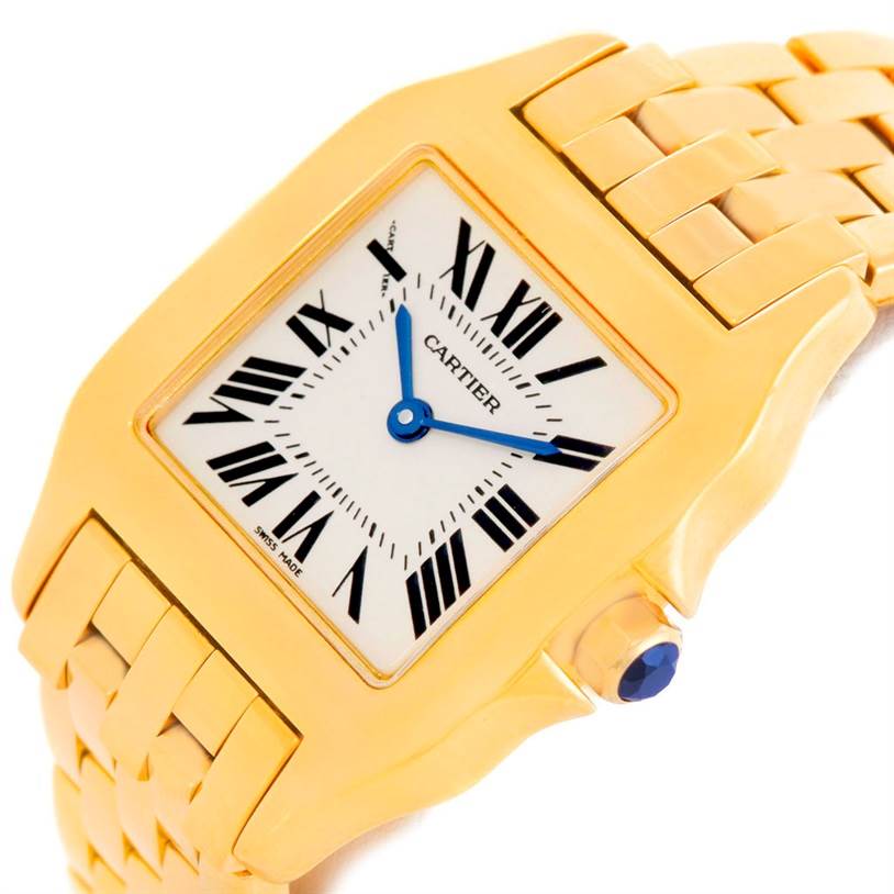 This image showcases a close-up angled view of the Cartier Santos Demoiselle W25062X9 Women
s Yellow Gold Silver Dial W25062X9 Women
s Yellow Gold Silver Dial watch, highlighting its face, bezel, crown, and part of the bracelet.