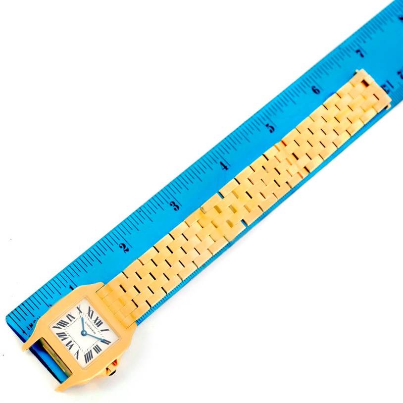 This image shows the Cartier Santos Demoiselle W25062X9 Women
s Yellow Gold Silver Dial W25062X9 Women
s Yellow Gold Silver Dial watch from a top-down angle, highlighting the face, case, and a portion of the bracelet.